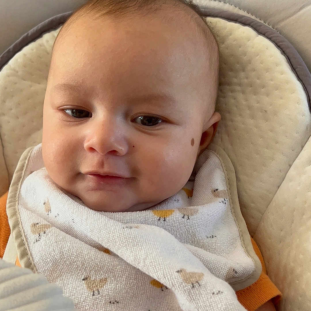 Sohan participe au concours pour gagner de l'argent avec cette photo : baby, infant, bib, toy, hand, seat, cushion, face, expression, comfort, clothing, child, cute, indoors, portrait, skin, head, smile, person, young