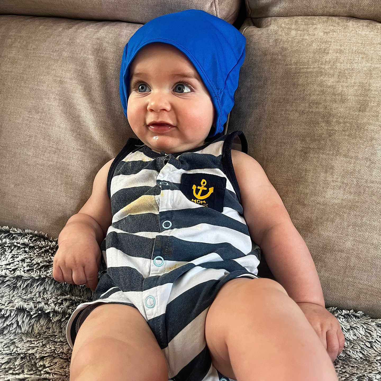 Lenny a rejoint le concours — aidez-le/la à gagner de superbes lots ! anchor_emblem, baby, beige_couch, blue_bonnet, casual_clothing, child, chubby_cheeks, couch, curious, cute, happy, indoors, infant, plush_blanket, portrait, relaxed, sitting, smiling, soft_fabric, striped_onesie