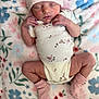 newborn, baby, sleeping, onesie, hat, socks, blanket, floral_pattern, infant, cute, cozy, soft, peaceful, resting, person, skin, hands, legs, indoors, portrait