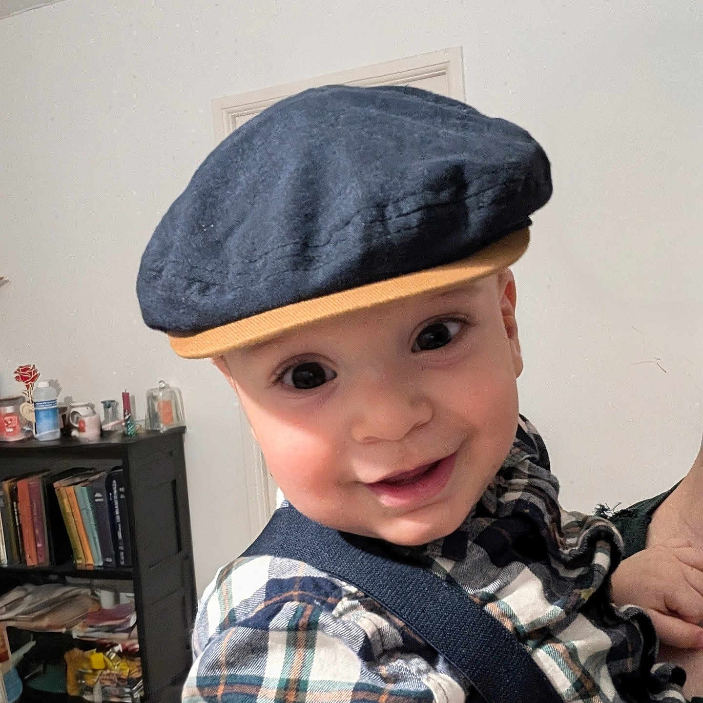 Fatah Juba participe au concours pour gagner de l'argent avec cette photo : baby, books, bookshelf, cap, child, clothing, cute, face, furniture, hand, happy, hat, headwear, indoor, person, plaid_shirt, portrait, smiling, suspenders, young