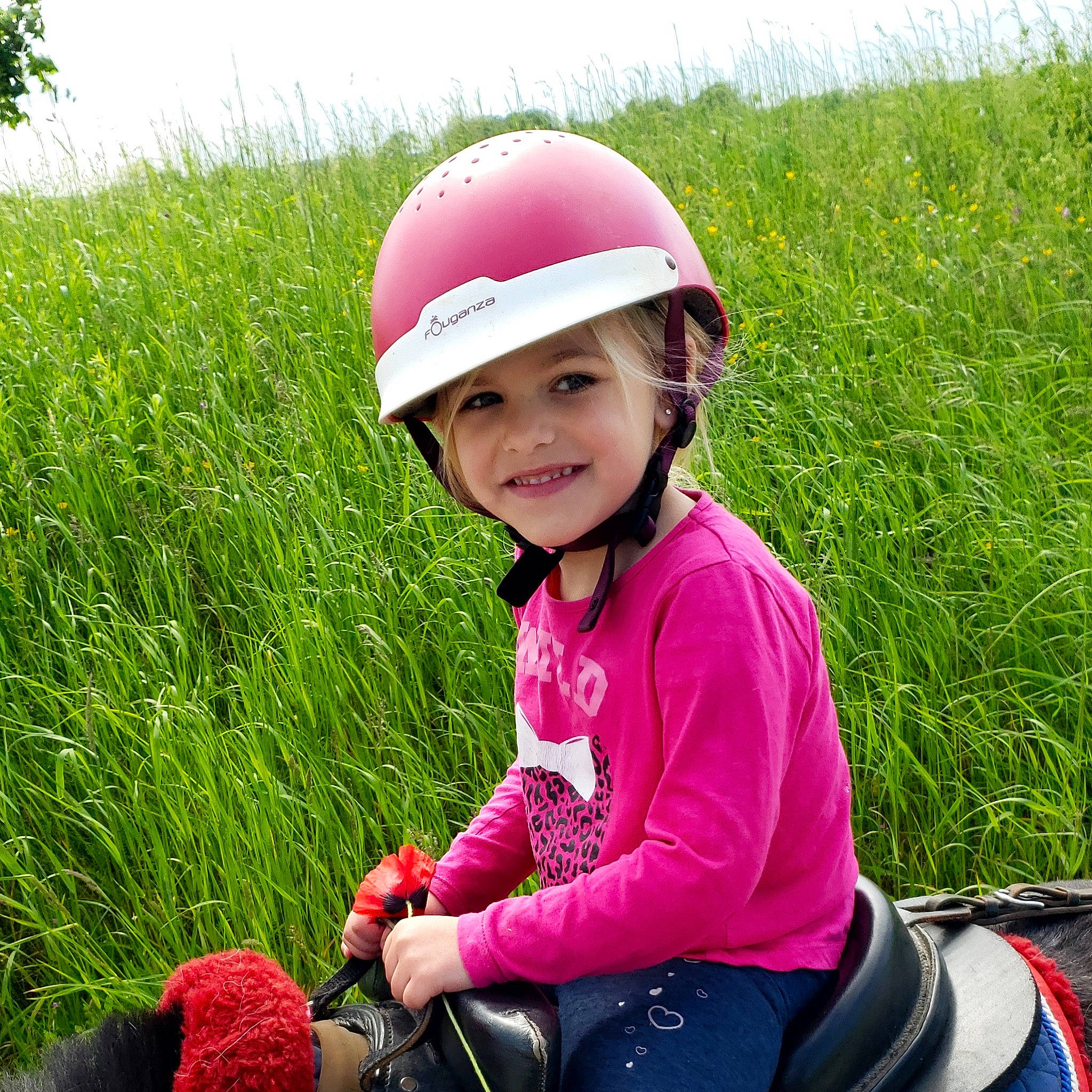 Noline a rejoint le concours — aidez-le/la à gagner de superbes lots ! bicycles_equipment_and_supplies, child, equestrian_helmet, face, fun, grass, happy, hard_hat, headwear, helmet, horse, joy, leisure, magenta, people_in_nature, person, personal_protective_equipment, pink, recreation, riding_toy