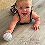 Alba participe au concours pour gagner de l'argent avec cette photo : baby, child, crawling, smiling, happy, indoor, floor, wooden_floor, toys, ball, blond_hair, blue_eyes, patterned_clothing, hand, face, person, infant, cute, playful, home
