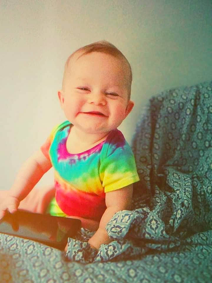 Scarlett is registered to the contest to win money with this photo: baby, baby_products, baby_toddler_clothing, cheek, child, comfort, eye, flooring, hair, happy, head, joy, linens, pattern, person, room, sitting, skin, sleeve, smile