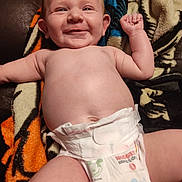 Grayson is registered to the contest to win money with this photo: arm, baby, blanket, child, closeup, cute, diaper, facial_expression, hand, happy, indoor, infant, lying_down, mickey_mouse, newborn, person, skin, smiling, soft_texture, tiger_stripe_pattern