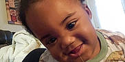 Jayden joined the competition — help win amazing prizes! toddler, child, smiling, pajamas, dinosaur_pattern, drool, hair_pigtails, face, living_room, couch, blanket, door, window, indoor, person, cute, happy, closeup, portrait, casual