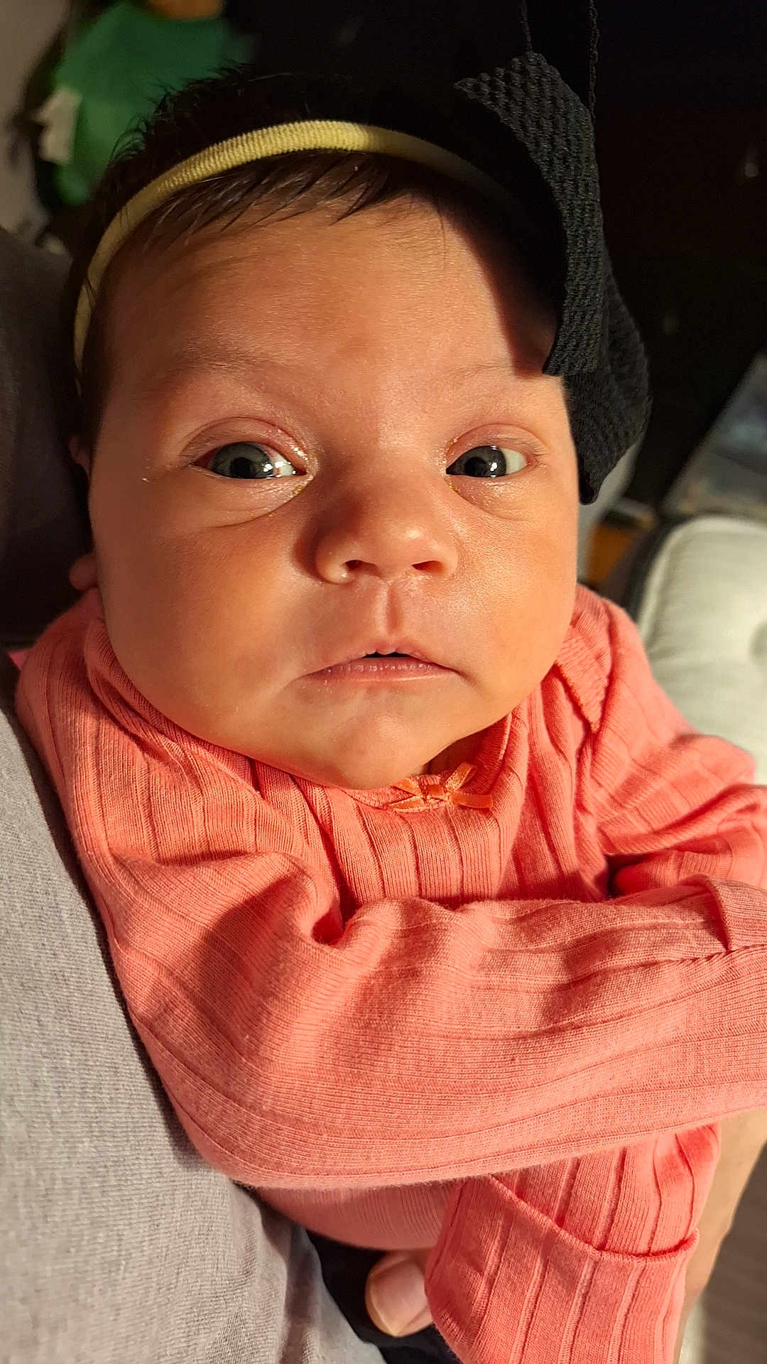 Xylena joined the competition — help win amazing prizes! baby, infant, face, headband, clothing, peach, ribbed, closeup, expression, curious, wide_eyes, skin, person, newborn, child, cute, indoors, holding, portrait, apparel