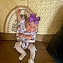 Ellie joined the competition — help win amazing prizes! baby, child, purple_bow, dress, socks, couch, blanket, quilt, indoor, sitting, cute, face, headwear, infant, person, small_child, looking, raised_arm, colorful, soft_furniture