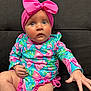 baby, child, infant, pink_bow, headband, colorful_clothing, blue, pink, floral_pattern, sitting, couch, indoor, cute, curious, portrait, hand, legs, closeup, person, young_child