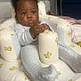 baby, bear_pattern, child, comfort, cozy, curious, cute, expression, face, furniture, hand, home, indoor, infant, inflatable_chair, pajamas, person, sitting, soft_lighting, young_child