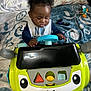 Amaree is registered to the contest to win money with this photo: baby, bed, blanket, car_toy, child, clothing, colorful, curly_hair, face, fisher_price, floor_covering, hands, indoor, person, pillow, play, remote_control, room, smiling_toy, toy