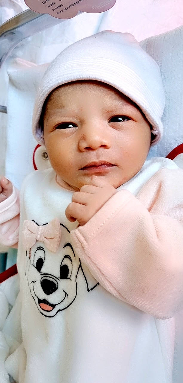 Inayah participe au concours pour gagner de l'argent avec cette photo : baby, baby_toddler_clothing, cheek, chin, eyebrow, eyelash, facial_expression, gesture, happy, headwear, lip, mouth, nose, person, photograph, pink, product, skin, sleeve, smile