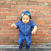 Mateo is registered to the contest to win money with this photo: toddler, child, blue_outfit, hat, brick_wall, wooden_floor, baby, standing, cute, outdoor, person, portrait, early_walk, casual_clothing, young_child, exploration, daylight, smiling, small_hands, innocence
