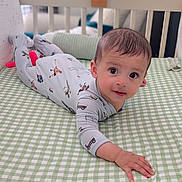 Yugam joined the competition — help win amazing prizes! baby, crib, onesie, infant, child, bed, green, white, checkered, face, hand, looking, lying, nursery, soft_lighting, cute, indoor, sleeping_area, furniture, young