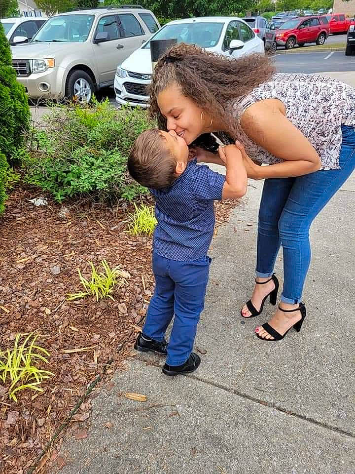 Kaeden is registered to the contest to win money with this photo: asphalt, automotive_exterior, automotive_tire, car, footwear, gesture, grass, joy, lawn, leg, motor_vehicle, people_in_nature, person, plant, road_surface, sandal, shoe, sneakers, tire, tree