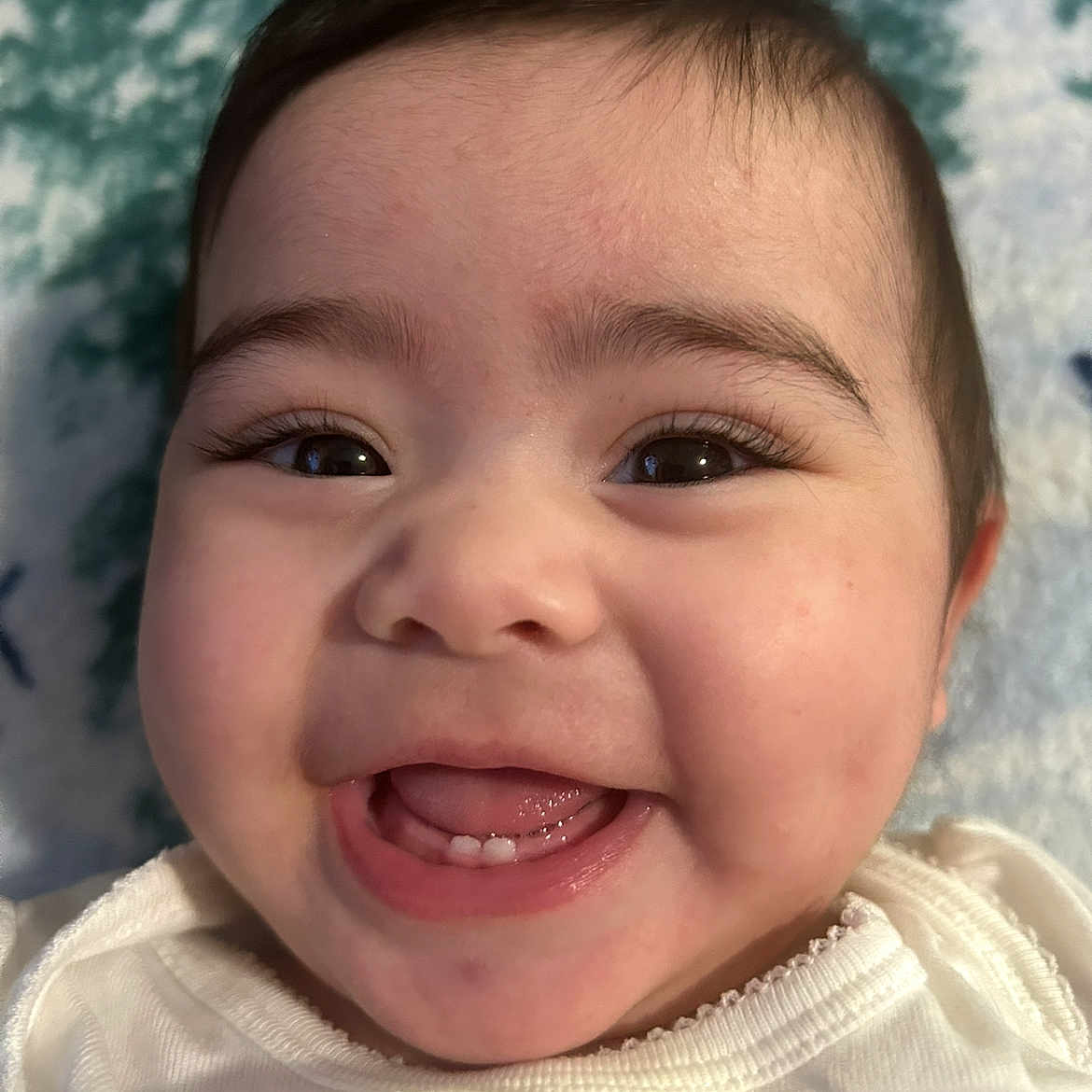 Ana is registered to the contest to win money with this photo: baby, blanket, child, close_up, clothing, cute, expression, eyes, face, happy, infant, mouth, portrait, skin, smiling, soft, teeth, tongue, white, young