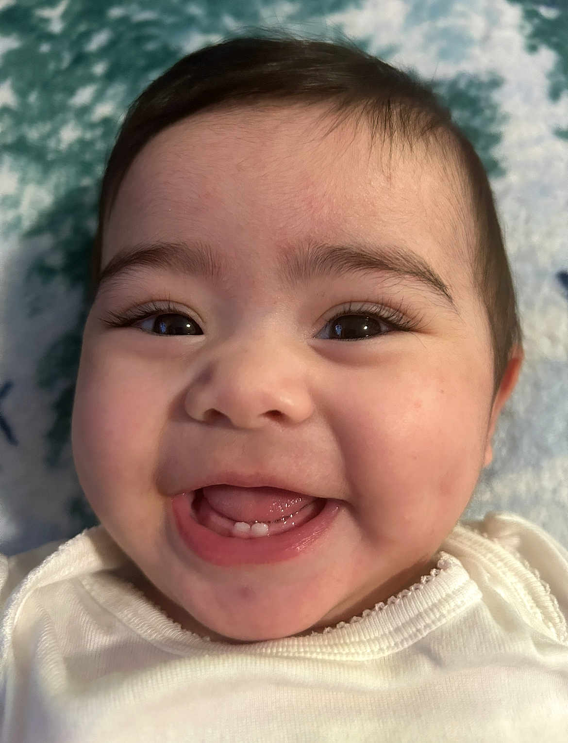 Ana is registered to the contest to win money with this photo: baby, smiling, close_up, face, infant, happy, cute, teeth, eyes, skin, mouth, tongue, clothing, white, blanket, soft, portrait, child, young, expression