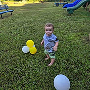 Kevin Goldston is registered to the contest to win money with this photo: toddler, child, grass, balloons, playground, slide, bench, outdoor, sunlight, trees, greenery, summer, nature, barefoot, smiling, cute, casual_clothing, park, fun, daytime