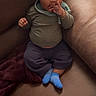 Kiyro joined the competition — help win amazing prizes! baby, blanket, blue_socks, casual_clothing, child, comfortable, couch, curly_hair, green_shirt, home, indoor, infant, leather, looking, person, portrait, relaxed, seated, small_child, young_child