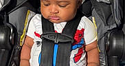 Kiyro is registered to the contest to win money with this photo: baby, black_hair, car_seat, casual_clothing, child, chubby_legs, curly_hair, cute, indoors, infant, person, portrait, resting, safety, seat_belt, sitting, spiderman_clothing, toddler, white_sock, young_child