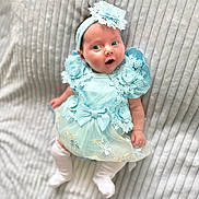 Ruby is registered to the contest to win money with this photo: baby, infant, blue_dress, headband, lace, flower, bow, white_tights, cute, portrait, soft_blanket, lying_down, child, adorable, small_hands, expression, innocent, newborn, fashion, soft_light