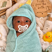 Jj is registered to the contest to win money with this photo: baby, infant, child, portrait, face, pacifier, hooded_towel, wrapped, mint_green, towel, rubber_duck, bath, bathroom, wooden_sign, baby_wash, blanket, soft_texture, cozy, indoor, newborn