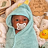 baby, infant, child, portrait, face, pacifier, hooded_towel, wrapped, mint_green, towel, rubber_duck, bath, bathroom, wooden_sign, baby_wash, blanket, soft_texture, cozy, indoor, newborn