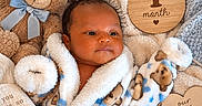 Jj is registered to the contest to win money with this photo: baby, blanket, blue, brown, child, cozy, face, heart, indoor, infant, milestone_photo, nursery, one_month_old, plush_toy, portrait, sleepy, smiling, stuffed_animal, teddy_bear, wooden_sign
