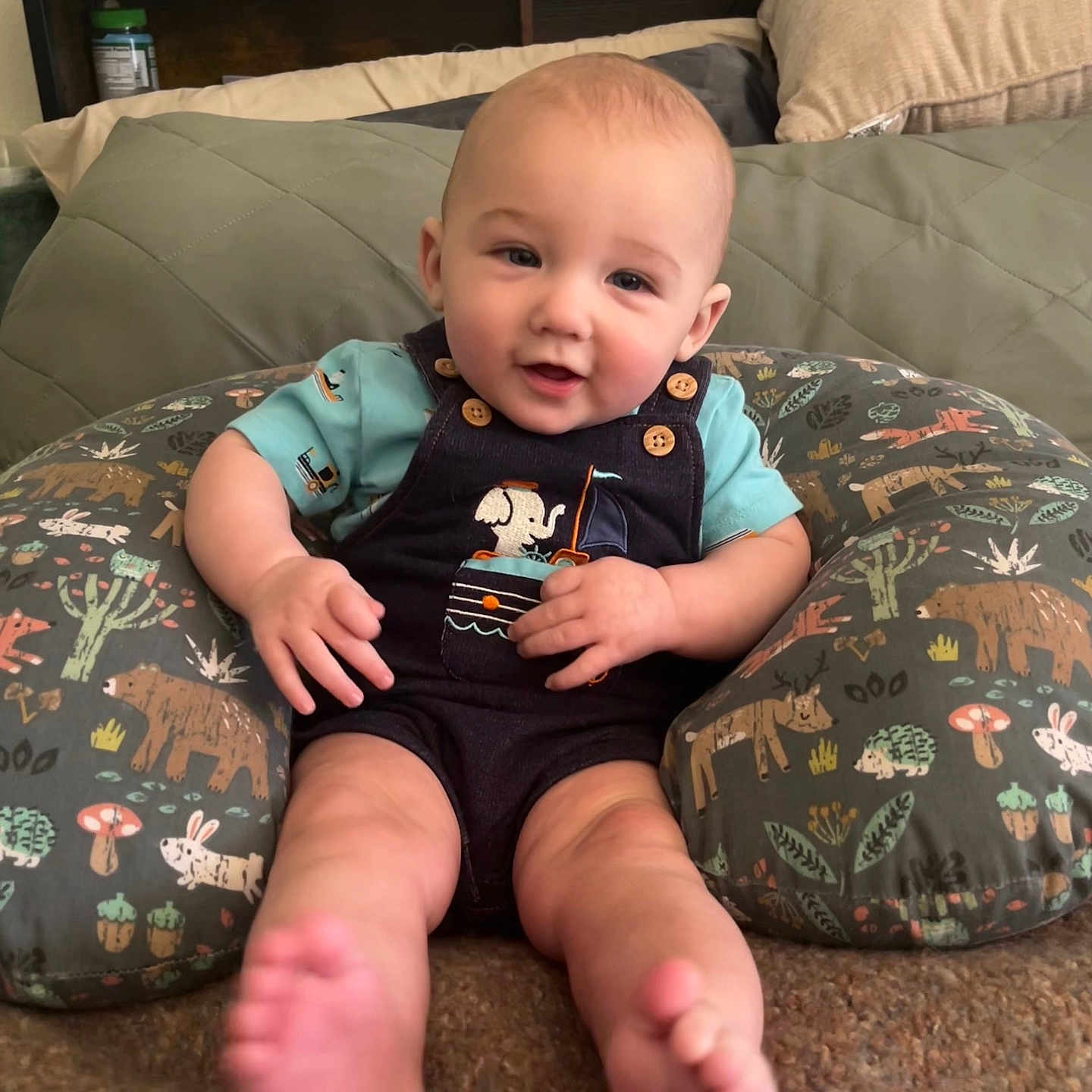 Sloan is registered to the contest to win money with this photo: baby, baby_supplies, bottle, carpet, child, clothing, cushion, cute, diapers, face, foot, happy, indoor, infant, patterned, person, portrait, shelf, sitting, smiling