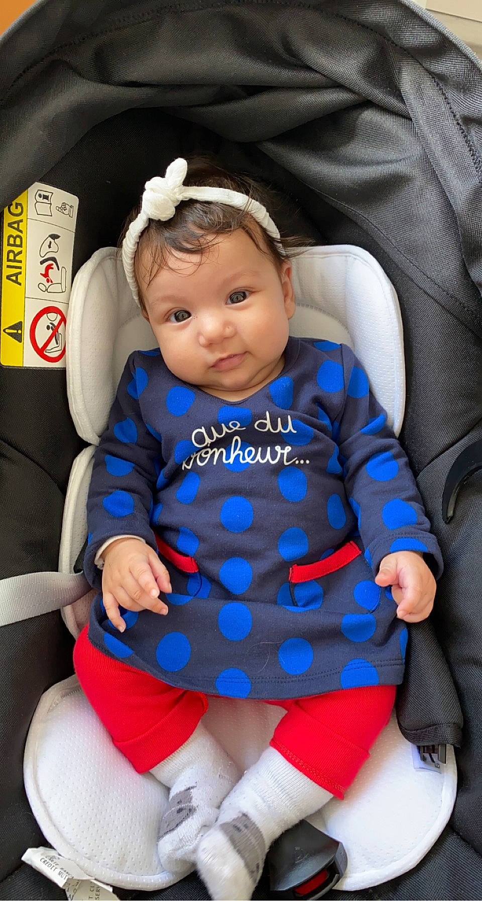 Naïa participe au concours pour gagner de l'argent avec cette photo : baby, baby_in_car_seat, baby_products, baby_toddler_clothing, car_seat, car_seat_cover, child, comfort, hair_accessory, headband, headpiece, lap, person, sitting, sock, toddler