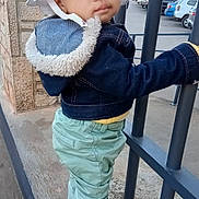 Almah a rejoint le concours — aidez-le/la à gagner de superbes lots ! baby, casual_clothing, child, curious, daytime, denim_jacket, green_pants, hat, innocent, metal_bars, outdoor, portrait, side_view, sneakers, standing, street, toddler, urban, white_hat, young_child