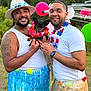 man, dog, outdoor, party, grass_skirt, lei, balloon, smile, tattoo, hat, facial_hair, white_shirt, watch, earring, beard, friendship, celebration, nature, pet, colorful