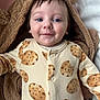 baby, child, infant, smiling, face, blue_eyes, hooded_blanket, bear_ears, cozy, onesie, cookie_pattern, cute, portrait, soft_texture, indoor, closeup, sleepwear, happy, person, toddler