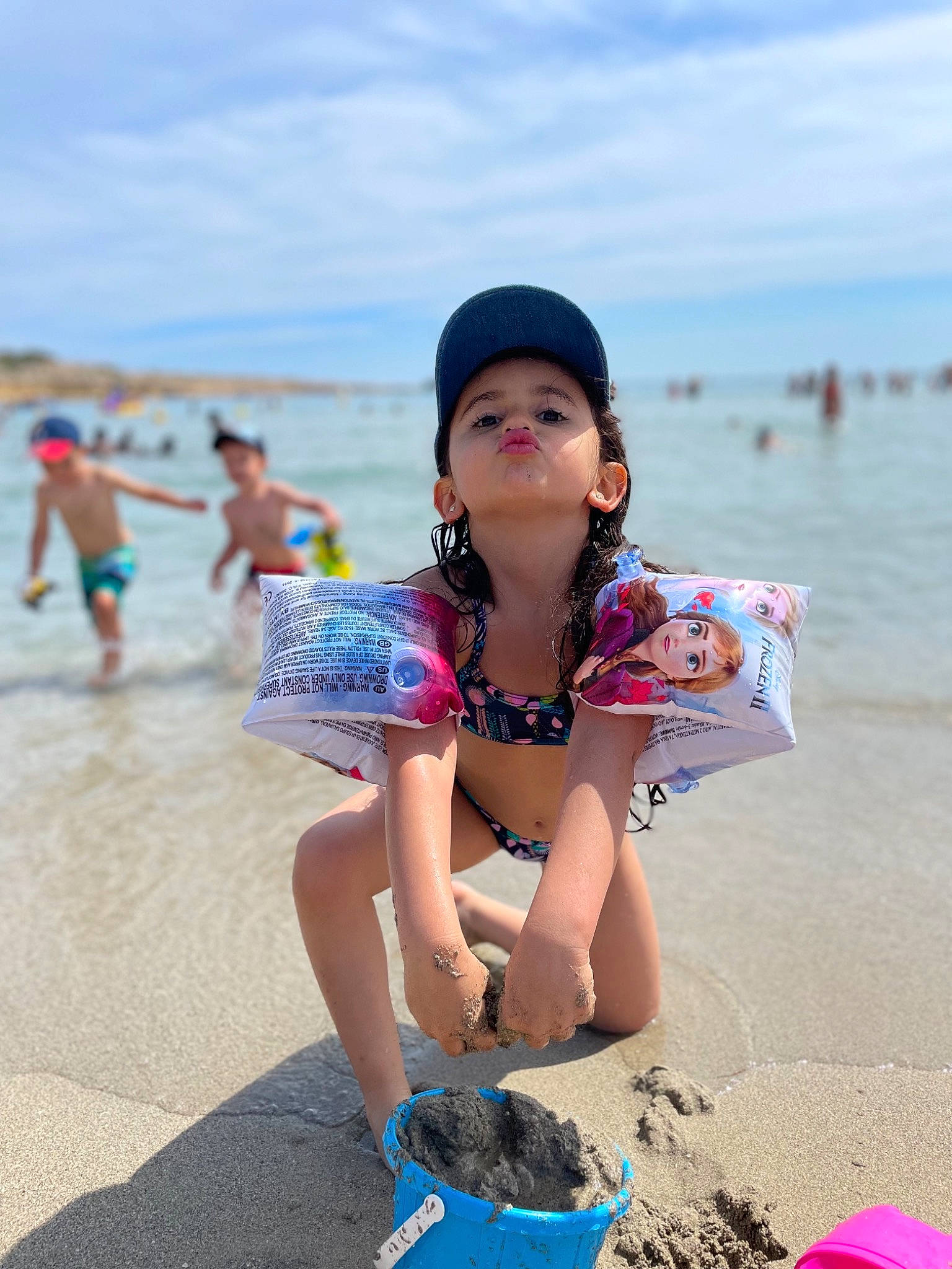 Mila a rejoint le concours — aidez-le/la à gagner de superbes lots ! azure, beach, beauty, cloud, fun, happy, hat, human, leisure, morning, natural_environment, people_on_beach, person, recreation, sand, sky, summer, swimwear, toddler, travel