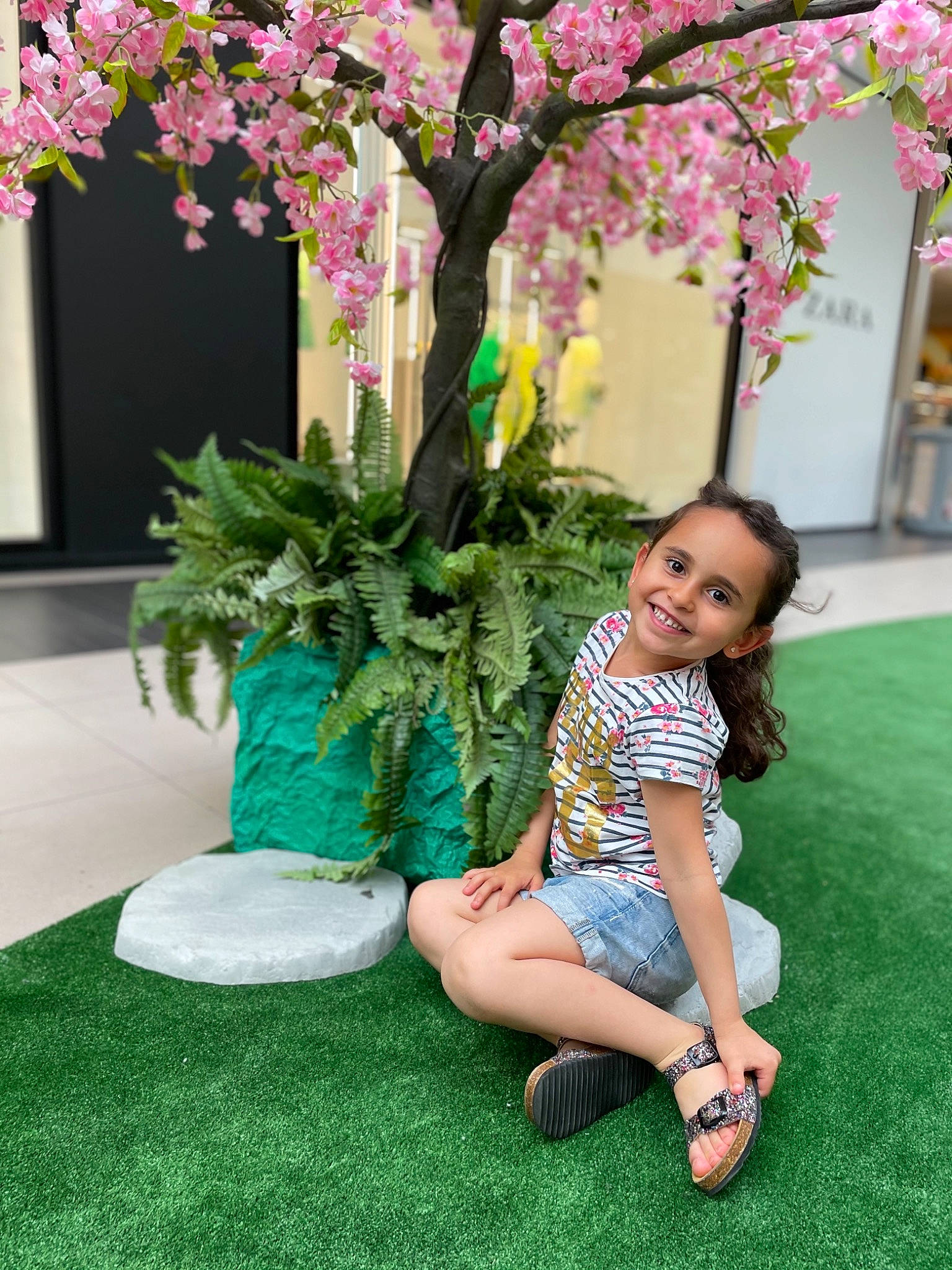Mila participe au concours pour gagner de l'argent avec cette photo : botany, flip_flops, flower, grass, green, happy, joy, lawn, leaf, leisure, person, petal, photograph, plant, public_space, sandal, shorts, smile, summer, thigh