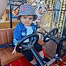 toddler, child, amusement_ride, steering_wheel, bucket_hat, denim_jacket, carousel, pig_statue, seat, playful, outdoor, daylight, funfair, cute, expression, toy_car, seatbelt, person, hat, footwear