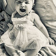 Leanna joined the competition — help win amazing prizes! baby, infant, child, smiling, happy, dress, headband, flower, sitting, blanket, cute, portrait, monochrome, black_and_white, feet, hands, face, candid, joyful, tulle