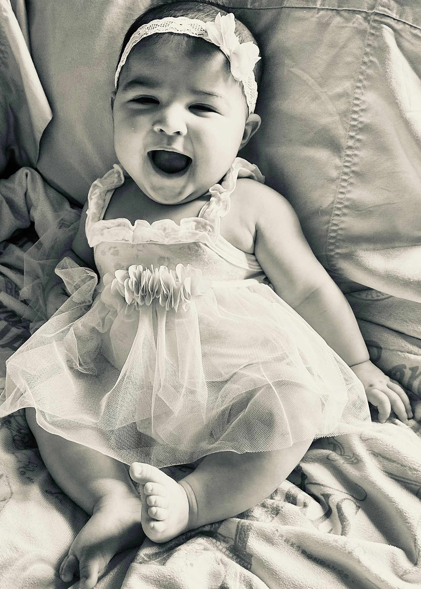 Leanna joined the competition — help win amazing prizes! baby, infant, child, smiling, happy, dress, headband, flower, sitting, blanket, cute, portrait, monochrome, black_and_white, feet, hands, face, candid, joyful, tulle