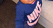 Saryha is registered to the contest to win money with this photo: toddler, child, person, face, eyes, clothing, sweatshirt, nike, pants, polka_dots, carpet, couch, indoor, footwear, socks, curly_hair, expression, standing, looking_up, cute