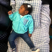 Saryha is registered to the contest to win money with this photo: baby, child, sleeping, hoodie, jeans, sneakers, blanket, pillow, hair_clip, earrings, indoor, couch, leather, texture, resting, cute, cozy, person, infant, relaxing