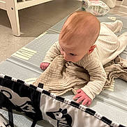 Ethan a rejoint le concours — aidez-le/la à gagner de superbes lots ! baby, infant, pajamas, blanket, floor_mat, zebra_pattern, black_and_white, crib, indoor, child, curious, crawling, soft_toys, hand, head, face, floor, home, nursery, playtime