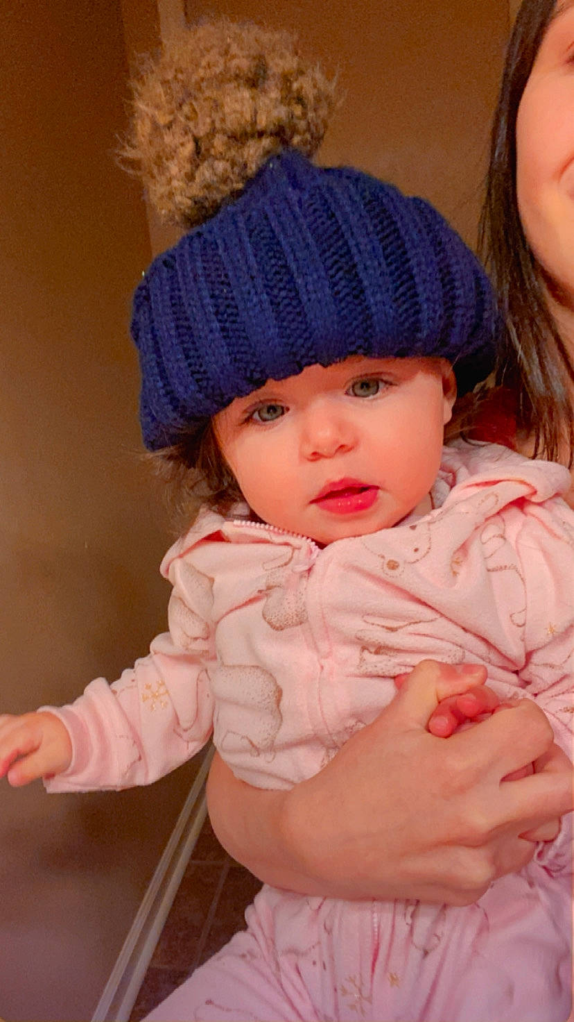 Rebecca is registered to the contest to win money with this photo: baby, baby_toddler_clothing, cap, cheek, chin, eye, face, gesture, happy, headgear, headwear, knit_cap, lip, nose, outerwear, person, pink, skin, sleeve, textile