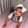 baby, child, smile, headband, bow, denim, overalls, pink_bed, crib, crawling, happy, cute, infant, indoors, portrait, person, baby_clothes, baby_skin, baby_hands, baby_face