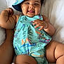 Anjayah joined the competition — help win amazing prizes! baby, child, infant, hat, romper, bed, blanket, toy, rattle, smile, tongue_out, arm, hand, face, skin, cute, relaxing, indoors, playful, happy