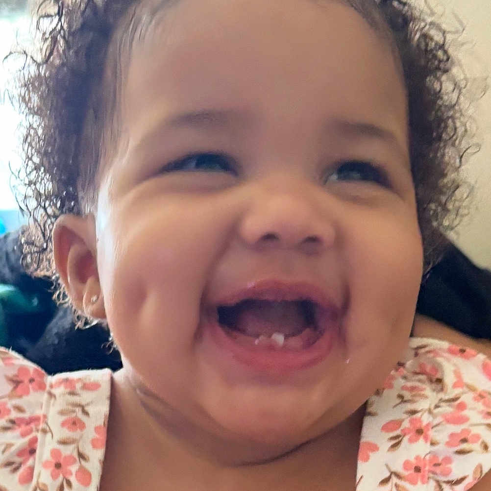 Anjayah is registered to the contest to win money with this photo: baby, child, closeup, curly_hair, cute, dimples, earrings, face, floral_dress, hair_accessory, happy, indoor, joy, mouth, person, portrait, skin, smiling, teeth, toddler