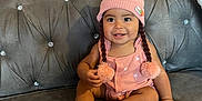 Chantelle joined the competition — help win amazing prizes! baby, child, smiling, pink_hat, pom_poms, knitted_hat, couch, gray_couch, indoors, happy, cute, sitting, infant, face, portrait, clothing, adorable, young_child, home, cozy