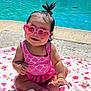 baby, child, sunglasses, heart_shaped, pink, swimsuit, pool, water, blanket, floral, toddler, outdoor, sunny, smiling, cute, hair_tie, sitting, barefoot, playful, summer