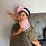 Chantelle is registered to the contest to win money with this photo: toddler, child, smiling, headband, flower, pink, leopard_print, skirt, couch, gray, indoor, happy, climbing, barefoot, cute, person, young_child, playful, furniture, portrait