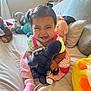 Chantelle joined the competition — help win amazing prizes! toddler, child, smiling, plush_toy, bed, pillow, window, natural_light, pink_dress, socks, stuffed_animals, indoor, happy, cute, person, hair_bow, toy, cozy, home, playful