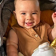 Noah joined the competition — help win amazing prizes! baby, child, smile, happy, plush_toy, seat, cozy, cute, infant, portrait, face, skin, clothing, buttoned_shirt, arm, hand, indoor, closeup, young, person