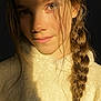 child, girl, portrait, braid, hair, face, closeup, young, light, shadow, warm_light, sweater, cozy, skin, expression, fashion, casual, indoor, soft_light, natural_light